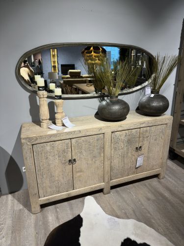 Sideboard mit antik anmutender Holzoptik dekoriert mit Vasen und Kerzenständern, darüber ein ovaler Wandspiegel in der Möbel Nachtsheim Ausstellung