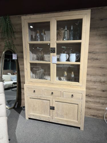 Vitrine in heller Holzoptik gefüllt mir Geschirr, Flaschen und Gläsern in der Möbel Nachtsheim Ausstellung