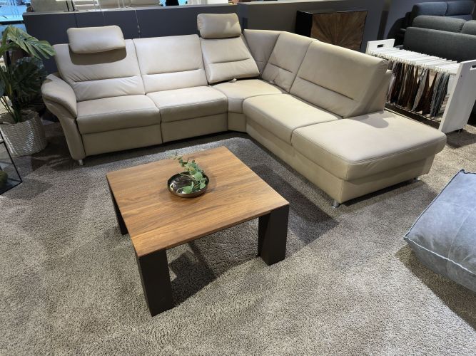 rustikaler, eckiger Couchtisch vor beigem Ecksofa in der Möbel Nachtsheim Ausstellung