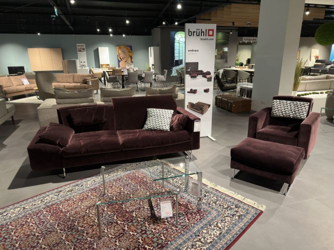 Bordeaux-rotes Sofa mit passendem Sessel und Fußhocker in der Möbel Nachtsheim Polstermöbel-Ausstellung