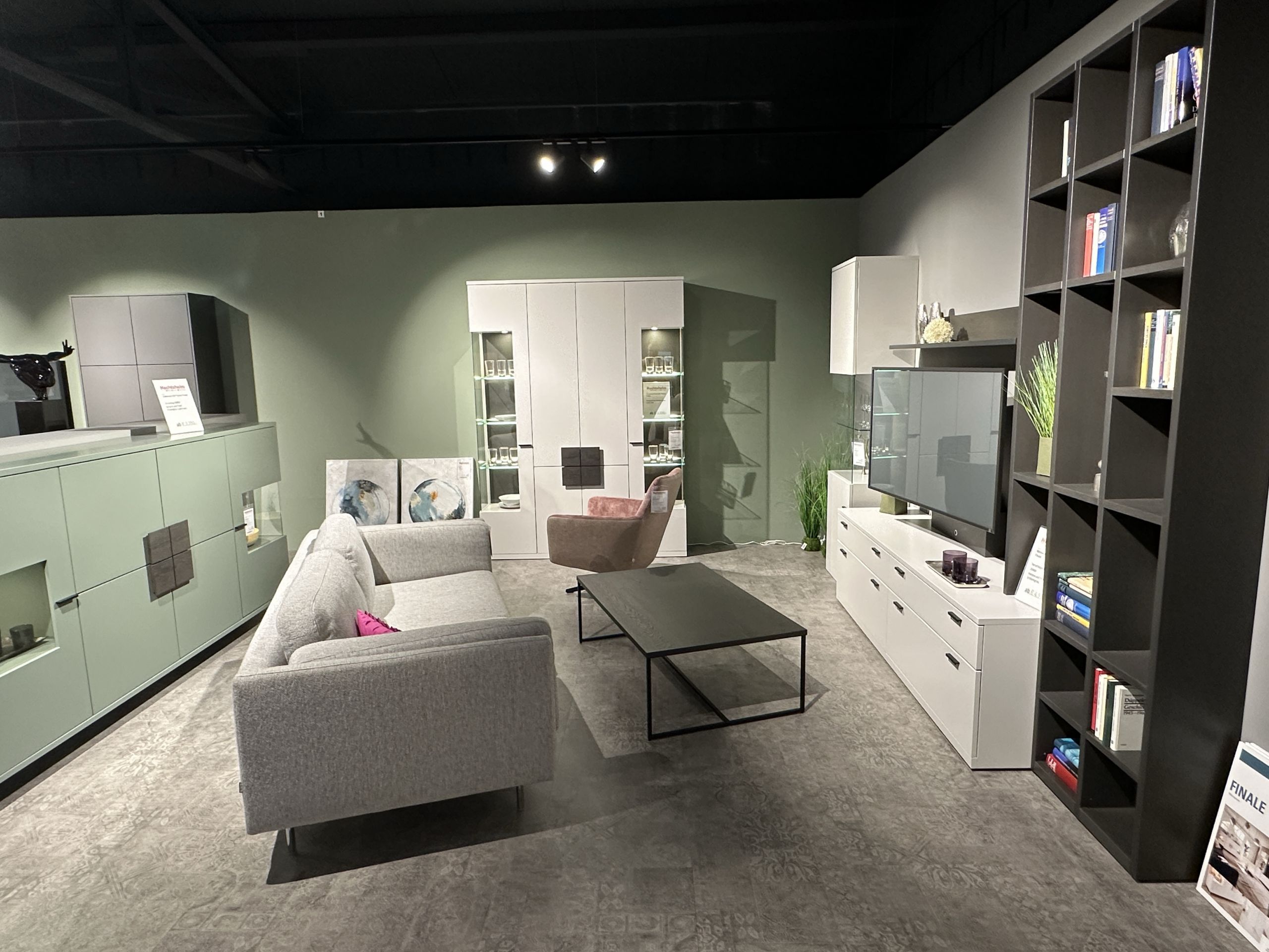 Modern eingerichtetes Beispiel-Wohnzimmer mit kleinem Sofa, Couchtisch, TV-Möbeln, Wohnwand und anderen Stauraummöbeln in der Möbel Nachtsheim Polstermöbel-Ausstellung